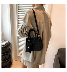 Detail of black crocodile pattern handbag with matching coin purse and adjustable strap