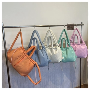 Puffy quilted shoulder bags in vibrant colors hanging neatly on a display rack