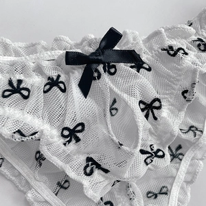 White lace thong for women with contrast black bow and ruffles in mesh fabric