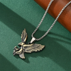Close-up of a vintage bronze eagle pendant on a silver metal chain with detailed feathers