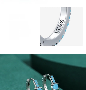 Detailed macro view of S925 sterling silver earrings with turquoise inlays and hallmarks