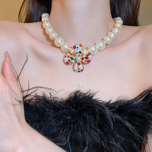 Macro view of vintage pearl necklace with multicolor gemstone pendant and gold finish