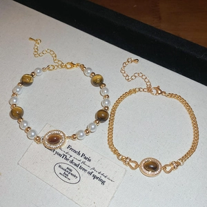Vue détaillée des bracelets en perles et œil de tigre avec chaînes élégantes en métal doré