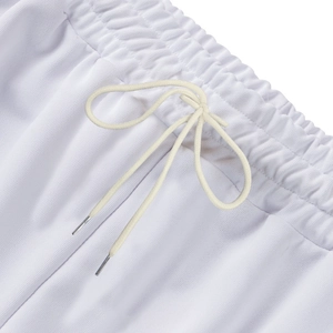 Macro detail of elastic waistband with white drawstring and metal tips on sports pants