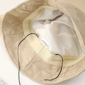 Detail of the quilted bucket hat interior with adjustable drawstring and sweatband