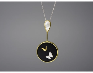 Detailed view of an elegant butterfly pendant featuring mop shell and bicolored butterflies