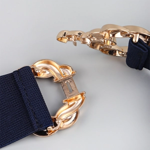 Detail of dark blue elastic waist belt featuring a polished gold interlocking metal buckle