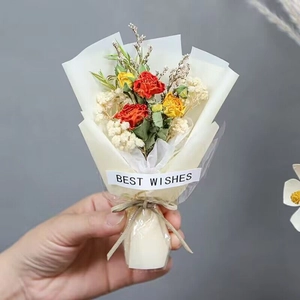 Mini dried flower bouquet with orange roses and baby's breath in translucent wrapping