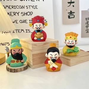 Detail of four handcrafted resin God of Wealth figurines with wood carving texture