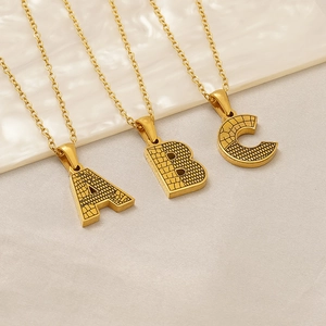 Vue détaillée de la texture d'écorce dorée sur les pendentifs lettres A, B et C
