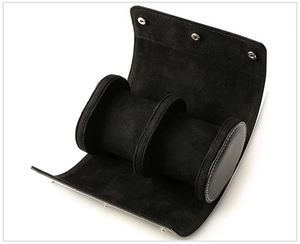 Detail of open black leather watch roll with soft velvet cushions and metal snap buttons
