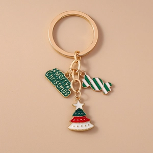 Detail of Christmas tree keychain with Merry Christmas tag and candy on beige background