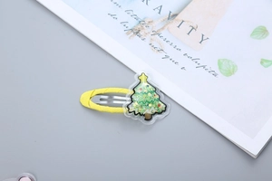 Macro shot of yellow Christmas tree hair clip with green sequins and glitter inside