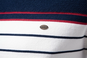 Macro detail of men's knit sweater featuring blue and red stripes on white fabric