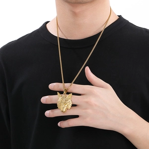 Close-up of golden Viking wolf head pendant necklace worn by a male model