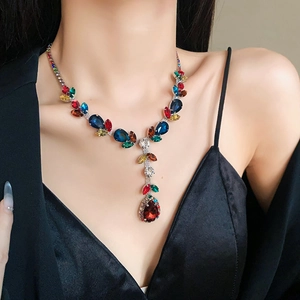 Close-up of a colorful teardrop gemstone necklace on model with vintage Y-shaped design
