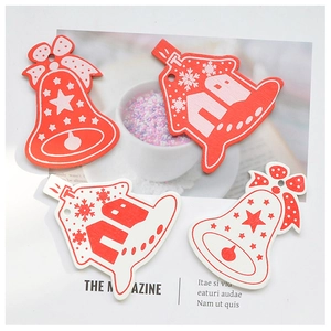 Close-up of red and white wooden Christmas ornaments with snowflake prints and bells
