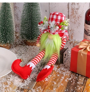 Detail of a Christmas gnome doll with long green beard and red checkered hat decor