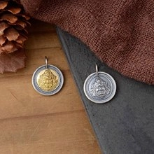 Macro detail of S925 sterling silver religious deity pendants with embossed vintage motifs