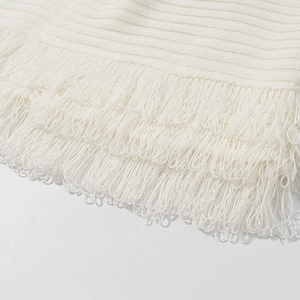 Nahaufnahme von hochwertigem weißem Strickstoff mit mehrlagigem Fransen-Detail-Design
