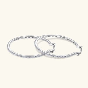 Detailed close-up of large silver hoop earrings featuring micro-pave white cubic zirconia