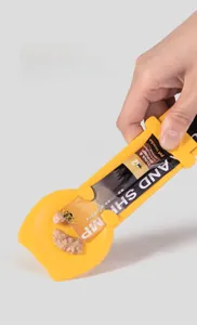 Close-up of sliding cat treat squeezer spoon in yellow plastic for mess-free pet feeding