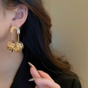 Detailed view of layered gold sequin disc earrings with hammered metal texture