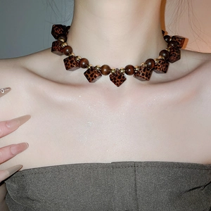 Detail of necklace with leopard print acrylic beads and vintage wooden beads
