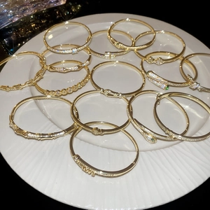 Detail showing 18k gold plated snake bracelet set with zircon stones on white ceramic tray