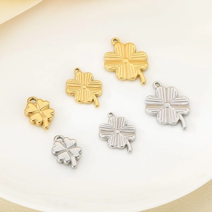 Detailed view of six gold and silver four-leaf clover pendants in various sizes