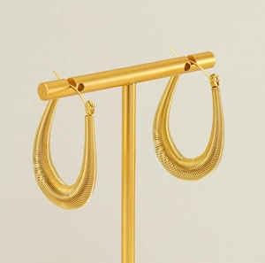 Detailed view of gold-plated U-shaped hoop earrings with spiral spring texture on display