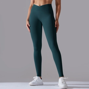 Detailed view of the crossover V-waist design on dark green seamless yoga leggings