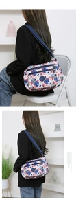 Macro detail of multi-zip nylon shoulder bag with artistic floral pattern and wide strap