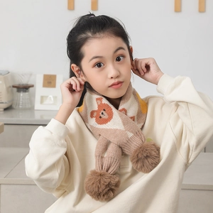 Détail d'une écharpe en tricot pour enfants avec motif ours et pompons doux