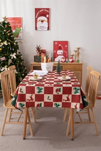 Christmas tablecloth detail with red and green plaid reindeer and festive motifs