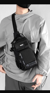 Close-up of black crossbody bag showing multiple zip pockets and side mesh storage