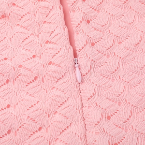 Gros plan sur la dentelle rose et la fermeture éclair invisible d'une robe col en V
