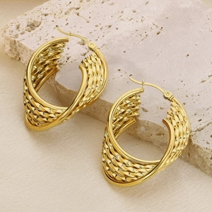 Détail de boucles d'oreilles en U dorées avec un design tressé en spirale texturé
