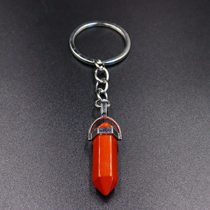 Macro detail of hexagonal orange stone pendant with polished silver alloy keychain