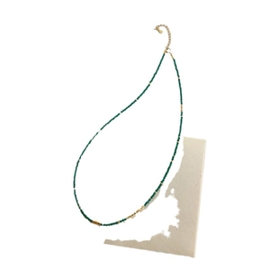 Minimalist stainless steel beaded necklace with green beads and gold metal accents
