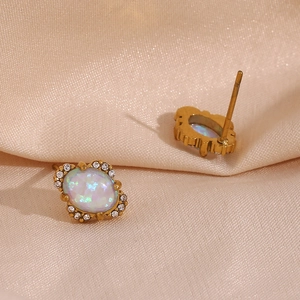 Close-up of vintage 18K gold petal earrings with opal stones on silk background