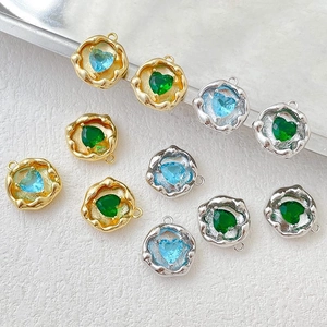 Close-up of 14k gold plated heart pendants with blue and green zircon stones for DIY jewelry