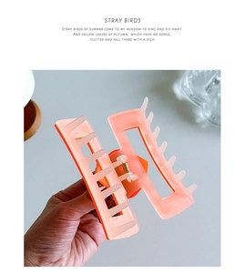 Detail view of large orange gradient hair claw clip showing spring mechanism and teeth
