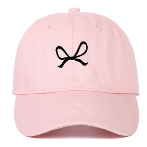 Close-up of pink cotton baseball cap featuring embroidered black bow ribbon detail