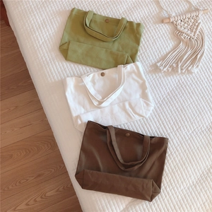 Three canvas tote bags in green, white and brown with vintage metal button closure