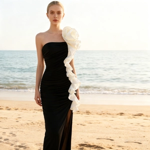 Detail of elegant black strapless mermaid dress featuring a large white 3D satin floral ruffle