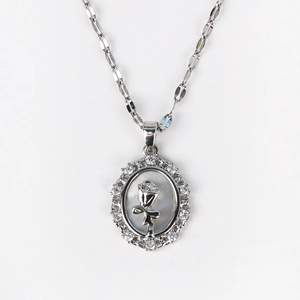 Detailed close-up of shell necklace pendant with silver rose and zircon frame