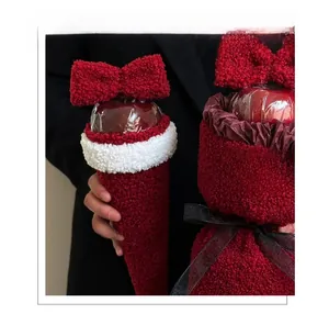 Close-up of a burgundy lamb wool apple wrap with a large plush bow for Christmas