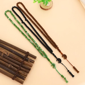 Muslim prayer beads in green, black, and amber brown with crescent moon star pendants