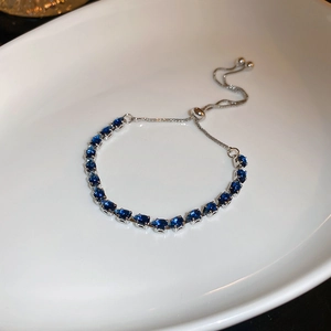 Macro shot of blue zircon teardrop bracelet with silver bolo sliding closure in a tray